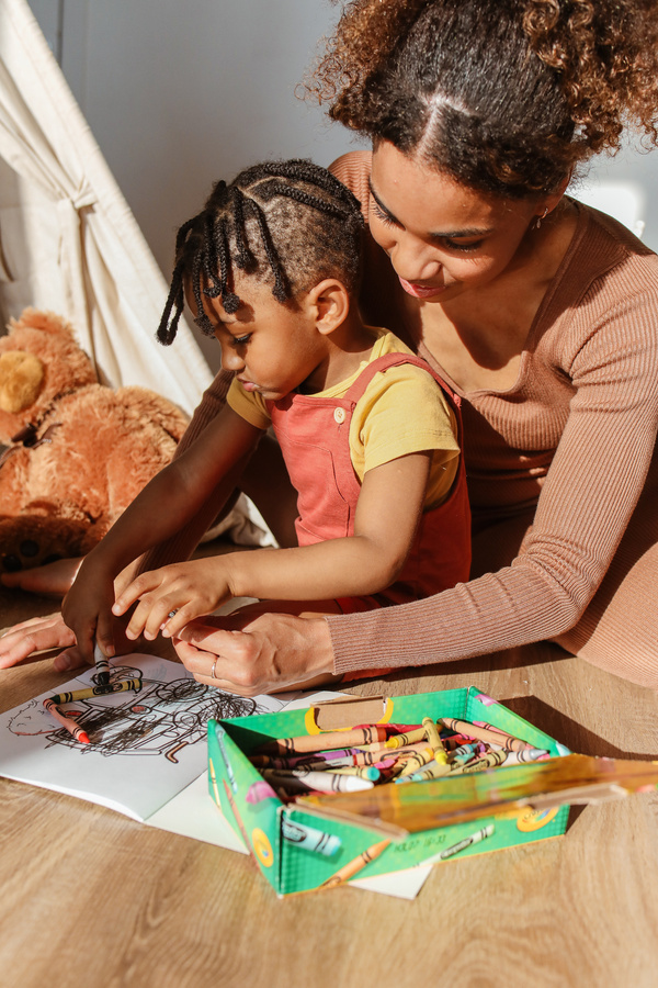 Mother Helping Baby with Coloring Book
